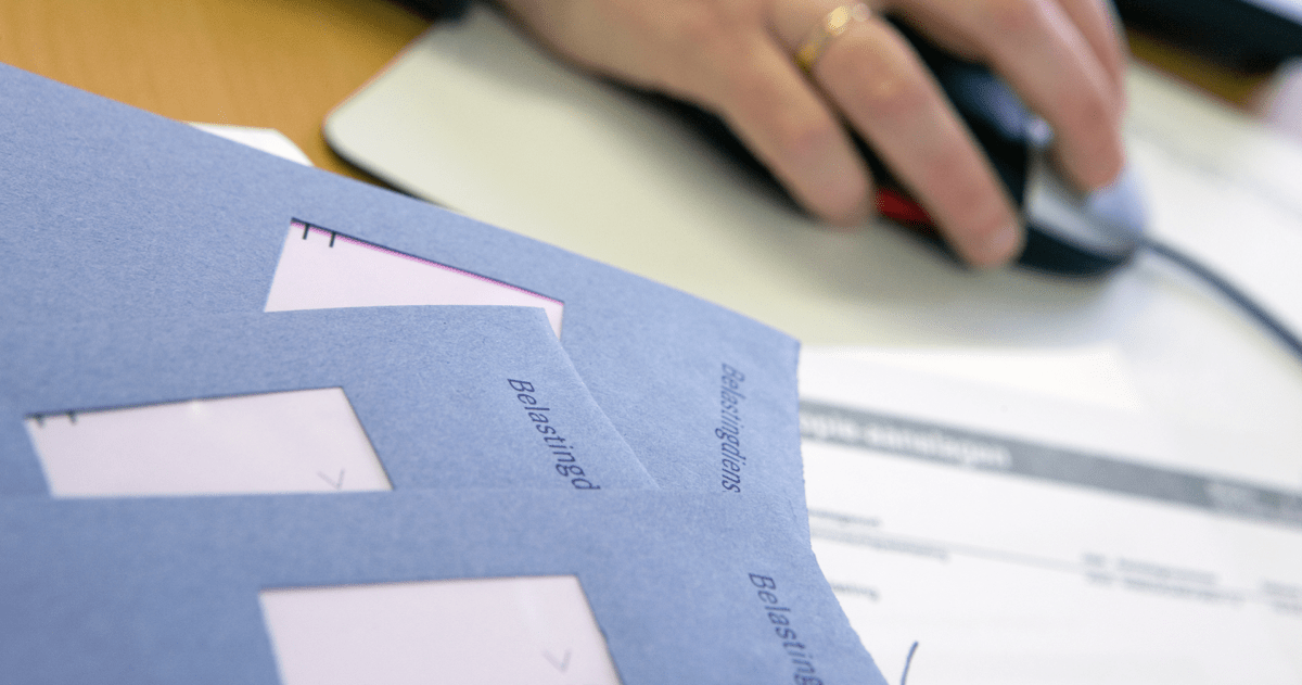 Enveloppen van de Belastingdienst op een bureau met een hand op een muis